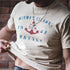 Person wearing a t-shirt with 'Midway Islands 1942 Battle' design and holding a belt.